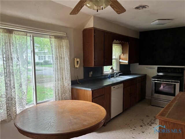 kitchen featuring stainless steel electric range oven, plenty of natural light, a sink, and dishwasher