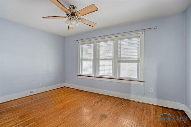empty room with hardwood / wood-style flooring, baseboards, and a ceiling fan