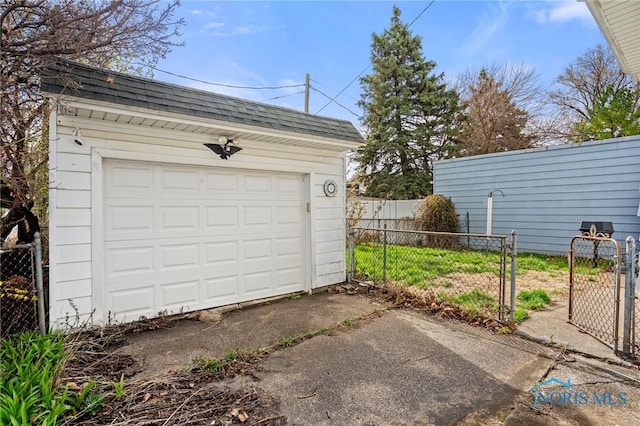 detached garage with driveway and fence