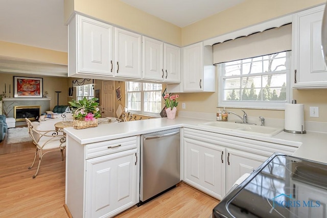 kitchen with a sink, black range with electric cooktop, dishwasher, a peninsula, and white cabinetry