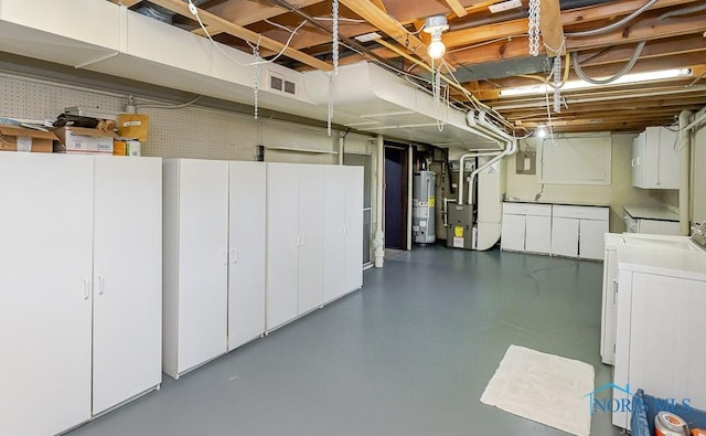 unfinished basement with visible vents, gas water heater, heating unit, and separate washer and dryer