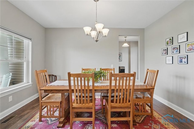 dining room with visible vents, baseboards, wood finished floors, and a chandelier