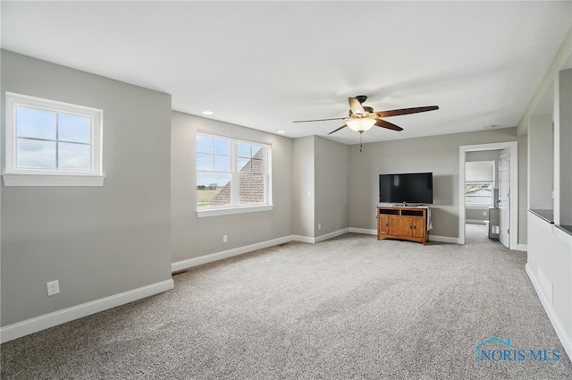 unfurnished living room featuring a healthy amount of sunlight, light colored carpet, and ceiling fan