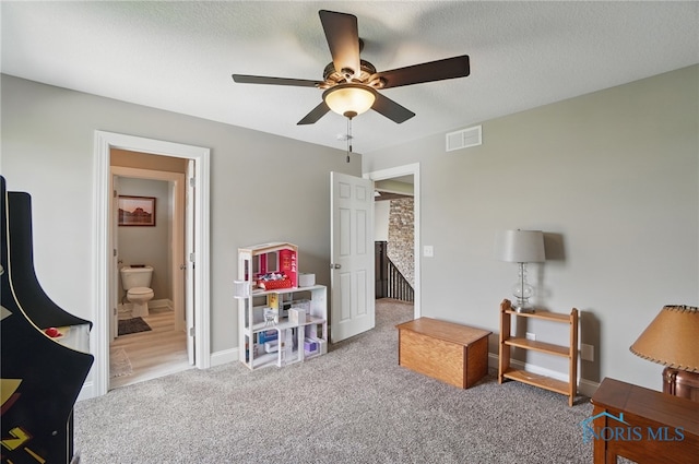 playroom featuring carpet flooring, a textured ceiling, baseboards, visible vents, and ceiling fan