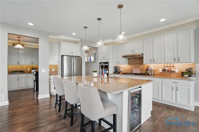 kitchen featuring backsplash, beverage cooler, stainless steel appliances, and recessed lighting