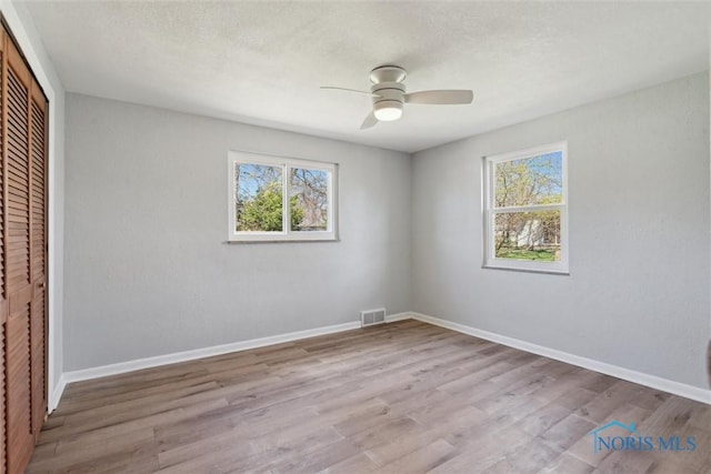 3105 W Laskey Rd, Toledo, OH 43613 - unfurnished bedroom featuring wood finished floors, visible vents, a closet, and multiple windows