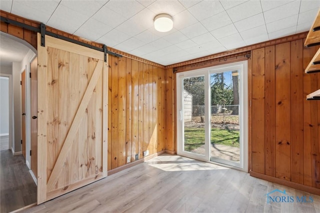3105 W Laskey Rd, Toledo, OH 43613 - doorway to outside featuring wood finished floors, wooden walls, baseboards, and a barn door