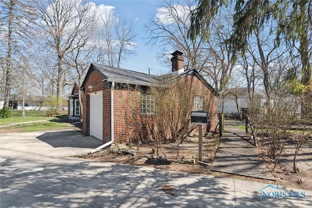 3105 W Laskey Rd, Toledo, OH 43613 - view of home's exterior with driveway, a chimney, brick siding, and a garage
