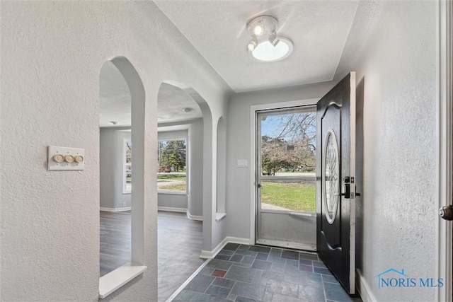 3105 W Laskey Rd, Toledo, OH 43613 - entryway with arched walkways, a textured wall, and stone tile floors