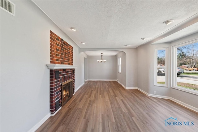 3105 W Laskey Rd, Toledo, OH 43613 - unfurnished living room featuring baseboards, a notable chandelier, wood finished floors, and visible vents