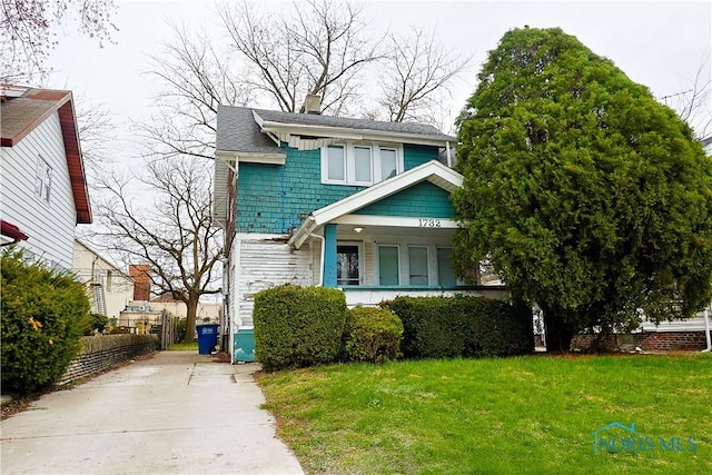 view of front of house featuring a front lawn, driveway, and a chimney
