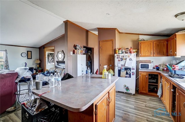 17341 Rd 139, Cecil, OH 45821 - kitchen featuring a center island, vaulted ceiling, white appliances, brown cabinets, and ornamental molding