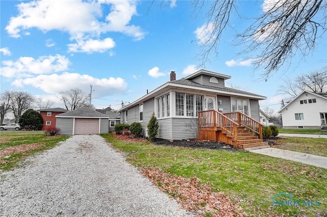 221 S Cherry St, Paulding, OH 45879 - bungalow-style house featuring a chimney, a front lawn, driveway, and an outbuilding