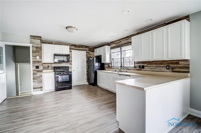 221 S Cherry St, Paulding, OH 45879 - kitchen with white cabinets, light countertops, decorative backsplash, black appliances, and a peninsula
