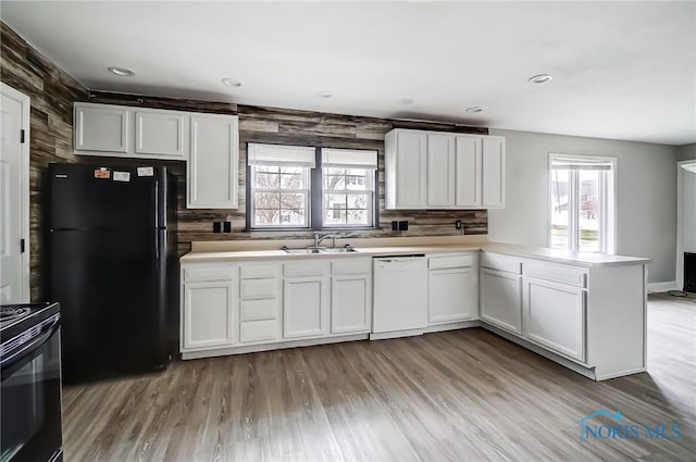 221 S Cherry St, Paulding, OH 45879 - kitchen featuring white cabinets, a sink, decorative backsplash, black appliances, and a peninsula