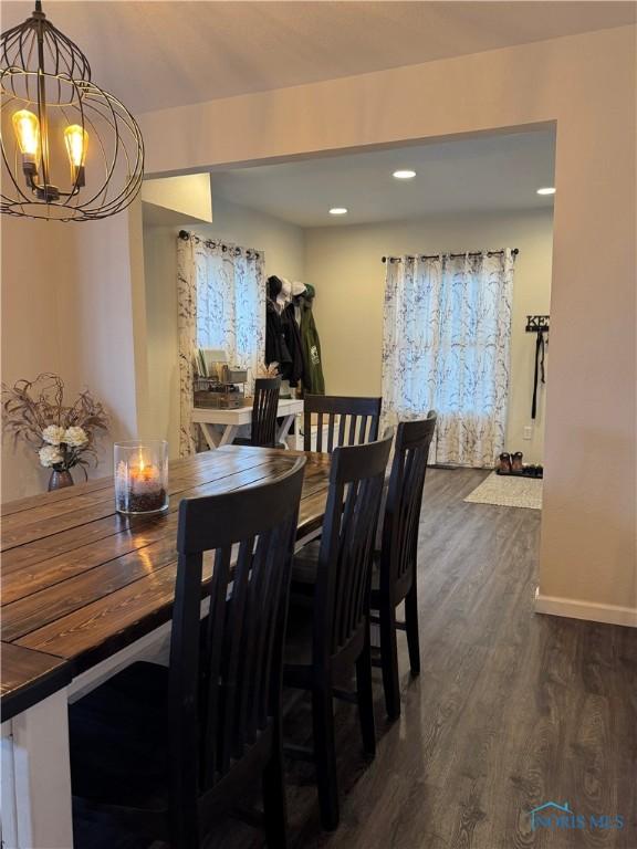 dining space featuring dark wood-type flooring, baseboards, recessed lighting, and an inviting chandelier