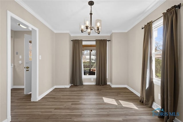 unfurnished dining area with a chandelier, wood finished floors, a wealth of natural light, and baseboards