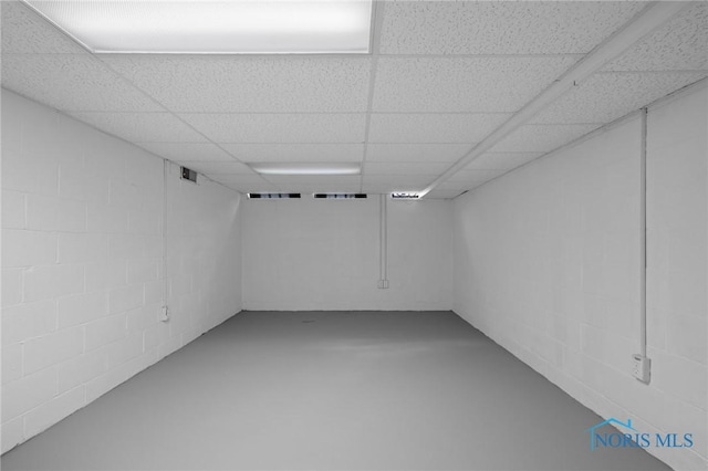 finished below grade area featuring concrete block wall and a drop ceiling