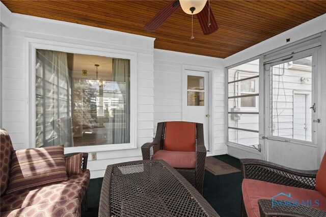 sunroom / solarium featuring ceiling fan with notable chandelier