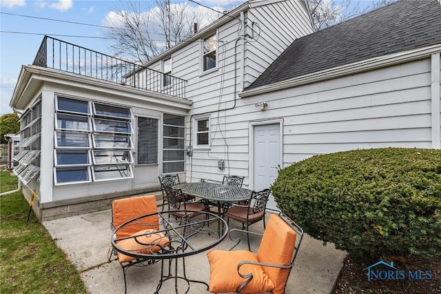 view of patio with outdoor dining area and a balcony