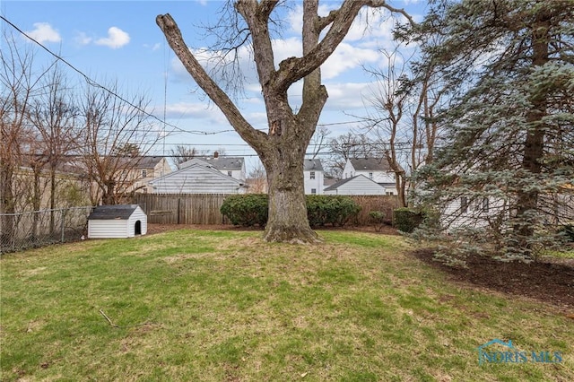 view of yard with a fenced backyard, a storage unit, and an outdoor structure