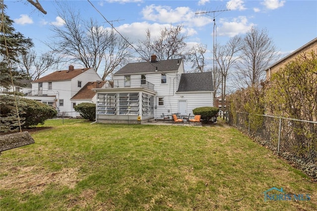 back of house featuring a chimney, a fenced backyard, a yard, a patio, and a sunroom