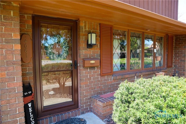 doorway to property featuring brick siding