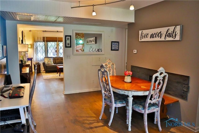 dining room with baseboards, visible vents, and hardwood / wood-style flooring