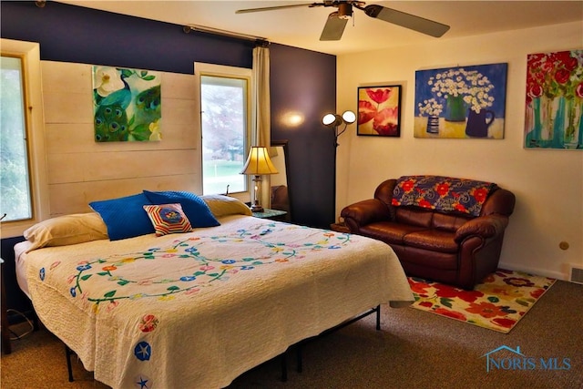 carpeted bedroom with a ceiling fan, visible vents, and multiple windows