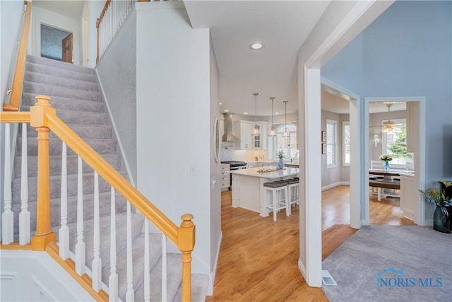stairway featuring baseboards, a ceiling fan, wood finished floors, and recessed lighting