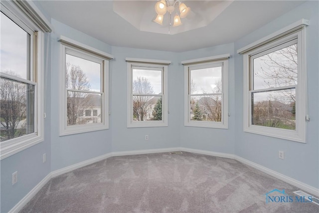 spare room featuring a ceiling fan, baseboards, and carpet