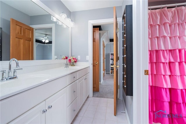 bathroom featuring a shower with shower curtain, tile patterned flooring, a sink, and double vanity