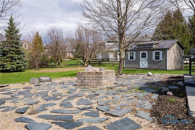 view of patio featuring fence, an outbuilding, and a shed