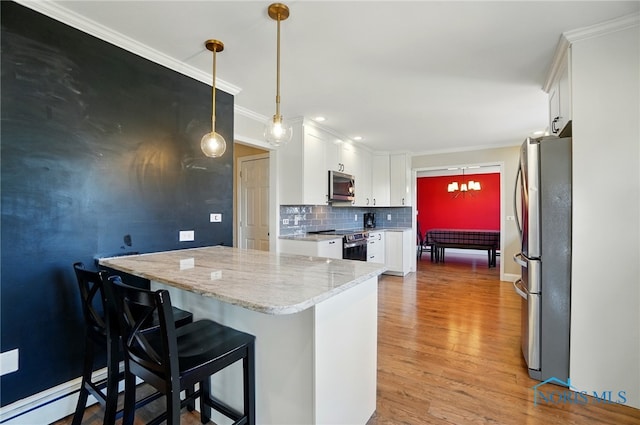 kitchen featuring light wood-style flooring, backsplash, white cabinetry, and appliances with stainless steel finishes