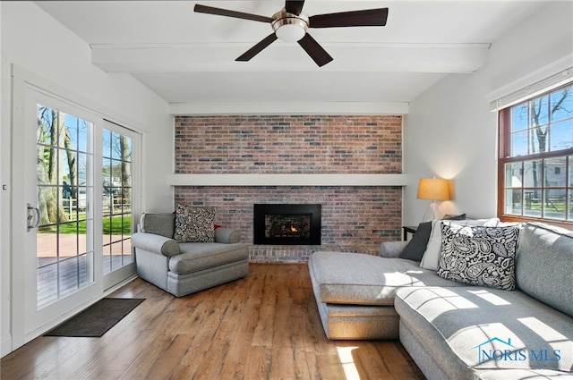 living area with beamed ceiling, wood-type flooring, and a wealth of natural light