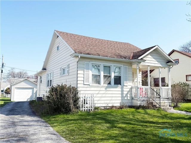440 Union Ct, Fostoria, OH 44830 - bungalow featuring a front lawn, driveway, an outbuilding, a porch, and a garage