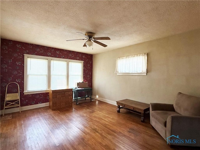 440 Union Ct, Fostoria, OH 44830 - living area with wallpapered walls, wood finished floors, ceiling fan, and plenty of natural light