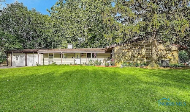 ranch-style house with a garage, driveway, a chimney, and a front yard