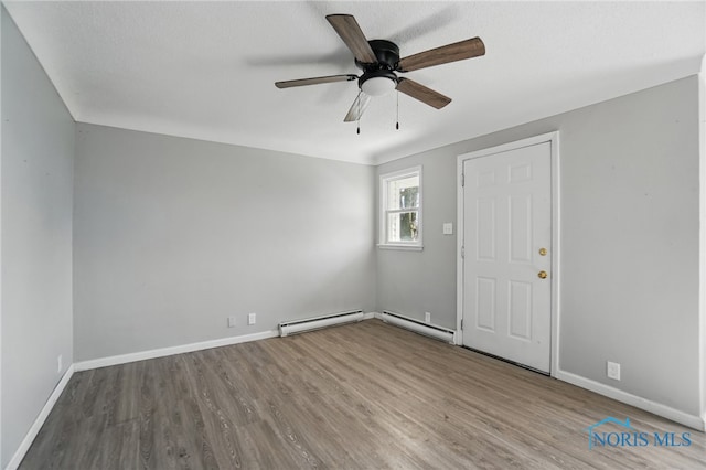 402 S 5th St, Continental, OH 45831 - unfurnished room with a baseboard heating unit, ceiling fan, wood finished floors, and baseboards