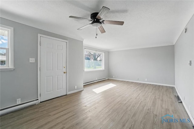 402 S 5th St, Continental, OH 45831 - unfurnished living room with a baseboard radiator, wood finished floors, ceiling fan, and baseboards