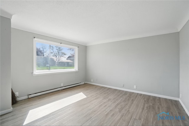 402 S 5th St, Continental, OH 45831 - spare room featuring baseboards, wood finished floors, and a baseboard radiator