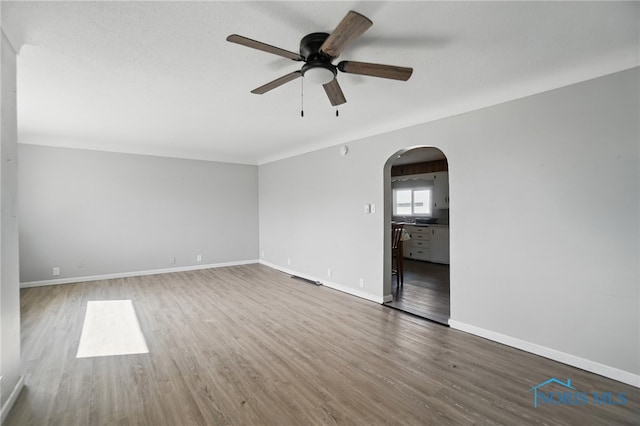402 S 5th St, Continental, OH 45831 - spare room featuring baseboards, arched walkways, ceiling fan, and wood finished floors