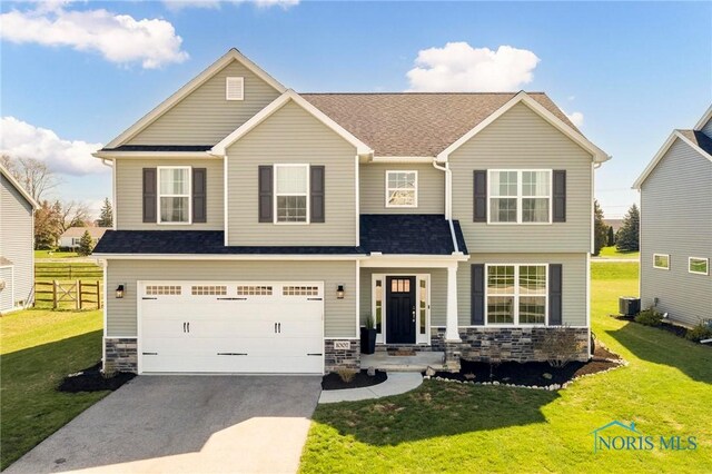 1007 Stoneleigh Rd, Perrysburg, OH 43551 - craftsman-style home with fence, a front lawn, central AC, driveway, and stone siding