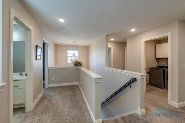 1007 Stoneleigh Rd, Perrysburg, OH 43551 - hallway with washing machine and dryer, light carpet, and an upstairs landing