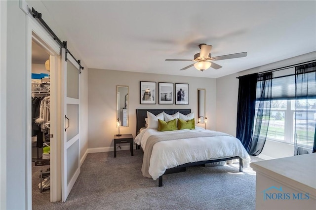 1007 Stoneleigh Rd, Perrysburg, OH 43551 - bedroom with a barn door, a ceiling fan, a walk in closet, carpet floors, and baseboards