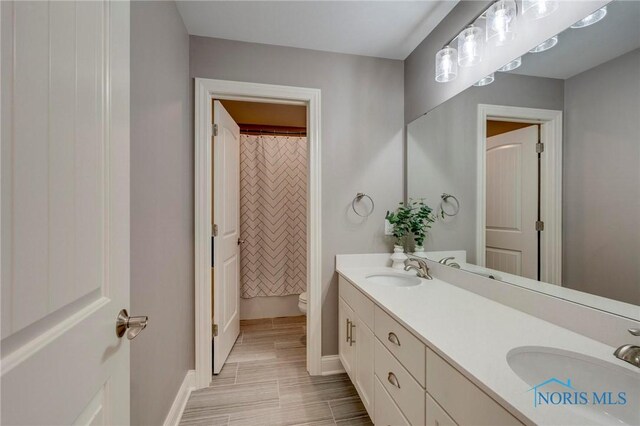 1007 Stoneleigh Rd, Perrysburg, OH 43551 - bathroom featuring baseboards, a sink, double vanity, and toilet