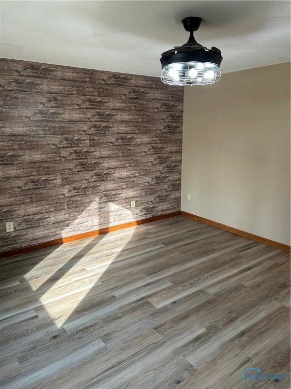 unfurnished dining area featuring wood finished floors and baseboards