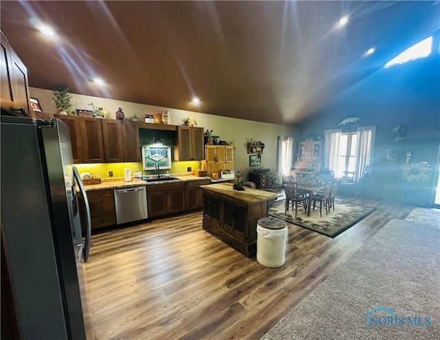 1673 Evan Dr, Defiance, OH 43512 - kitchen featuring appliances with stainless steel finishes, a sink, wood finished floors, vaulted ceiling, and light countertops