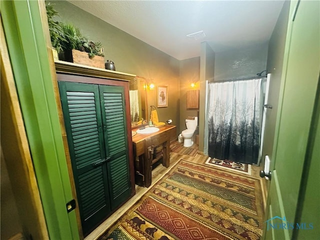 1673 Evan Dr, Defiance, OH 43512 - full bathroom with toilet, vanity, a shower with curtain, and wood finished floors
