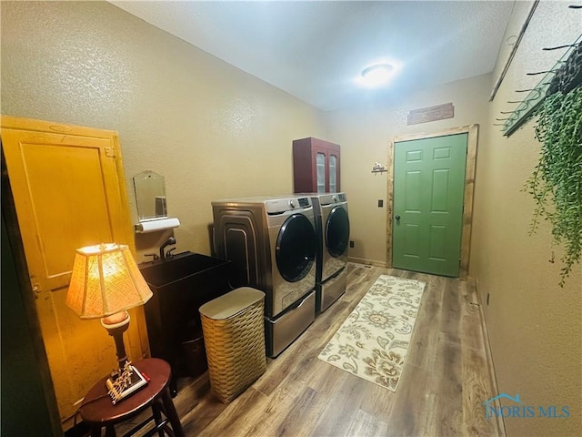 1673 Evan Dr, Defiance, OH 43512 - laundry room with washing machine and clothes dryer, light wood-type flooring, and a textured wall
